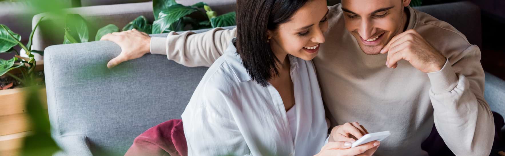 Par med mobil som läser om att bli skuldfri